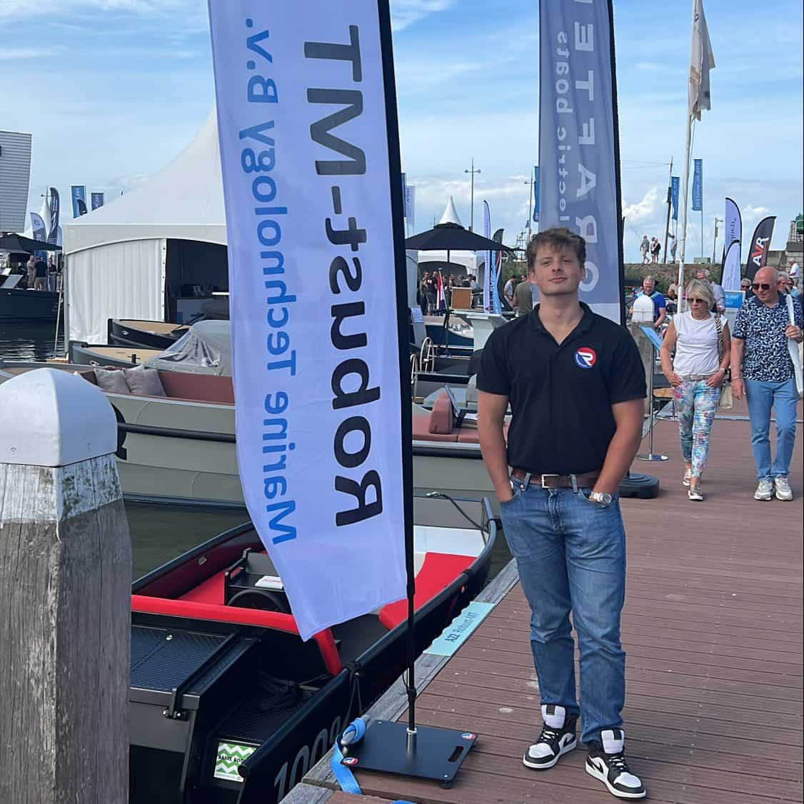 A man standing next to a boat on a dock.